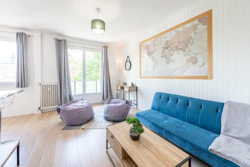 un salon avec un canapé bleu et une table dans l'établissement Beau Soleil Appartement au centre ville, à Annecy