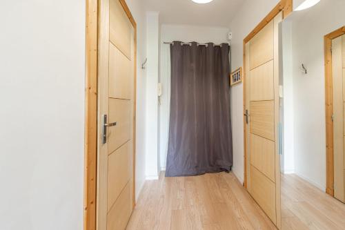 un couloir vide avec une porte et un rideau dans l'établissement Beau Soleil Appartement au centre ville, à Annecy