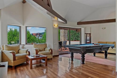 a living room with a pool table and two chairs at Wine Cellar Villa with Beautiful Garden in Sinaia - Busteni in Poiana Ţapului