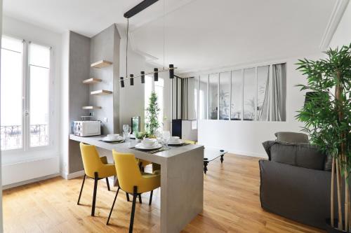 une cuisine et un salon avec une table et des chaises dans l'établissement Appartement Quartier Montmartre 3 Free Netflix, à Paris