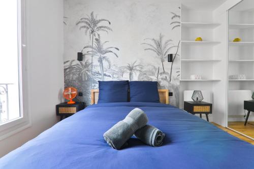 une chambre avec un lit bleu avec des oreillers bleus dans l'établissement Appartement Quartier Montmartre 3 Free Netflix, à Paris