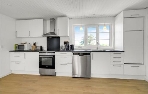 a kitchen with white cabinets and stainless steel appliances at 3 Bedroom Cozy Home In Fjerritslev in Fjerritslev