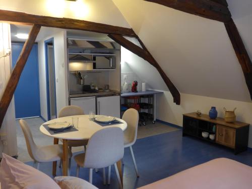 une cuisine et une salle à manger avec une table et des chaises dans l'établissement Charmant studio centre-ville, à Bourges