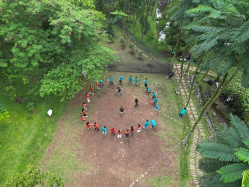 a group of people forming a circle in a park at Leuweung Geledegan Ecoldge in Kiarapayung 2