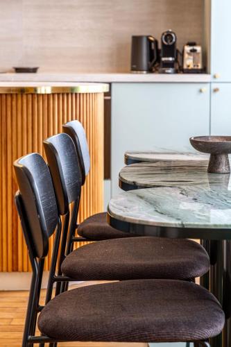 une table et quatre chaises avec une table et un comptoir dans l'établissement Habitat Parisien - Madeleine Galeries Lafayette, à Paris