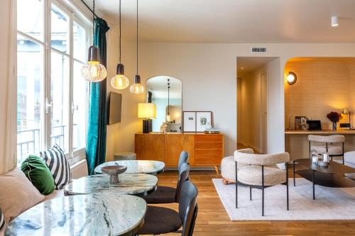 - un salon avec deux tables et des chaises dans l'établissement Habitat Parisien - Madeleine Galeries Lafayette, à Paris