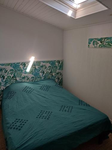 une chambre avec un lit avec une couette verte dans l'établissement Maison au calme, à Saint-Quentin-la-Poterie