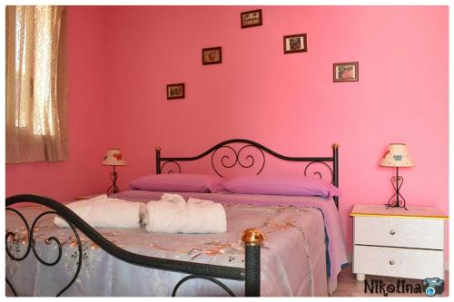 a pink bedroom with a bed with pink walls at Bellavista in Mazzeo