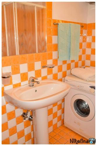 a bathroom with a sink and a washing machine at Bellavista in Mazzeo