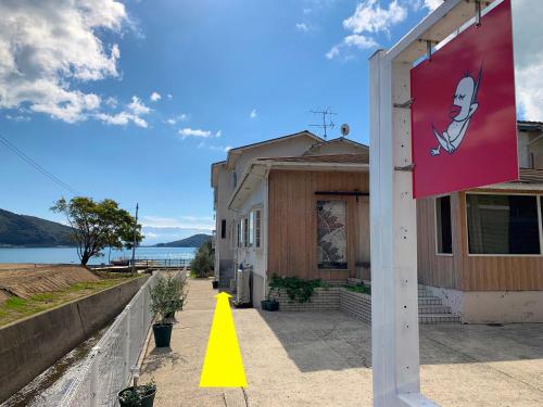 a building with a yellow cone in front of it at HATN HAT Guesthouse ハッツンハットハウス in Shodoshima