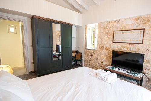a bedroom with a large bed and a tv at Lagadia Stone House in Agios Nikitas