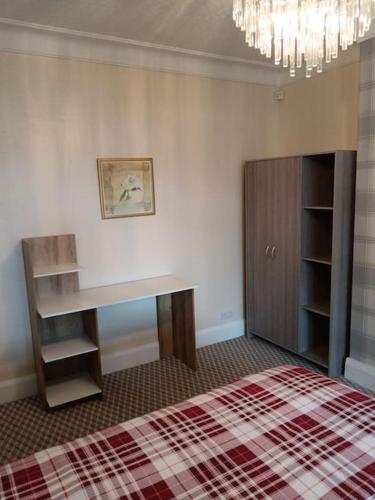 a bedroom with a bed and a desk and a chandelier at Sea View in Heysham