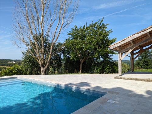 une piscine extérieure avec un pavillon et des arbres dans l'établissement Gite Mondurausse - avec piscine et vue sur la vallée, à La Salvetat-Belmontet