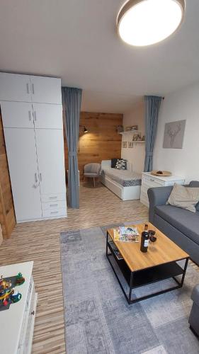 a living room with a couch and a table at Apartmán REZE Šumava in Železná Ruda