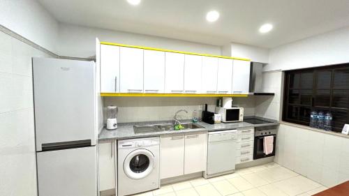 a kitchen with a sink and a washing machine at Casa Portela in Vila Nova De Cacela