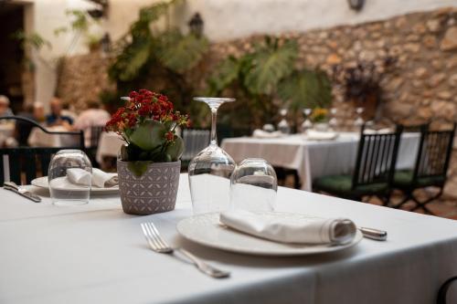 a table with plates and napkins and a wine glass at Hotel Nou Romà in Denia