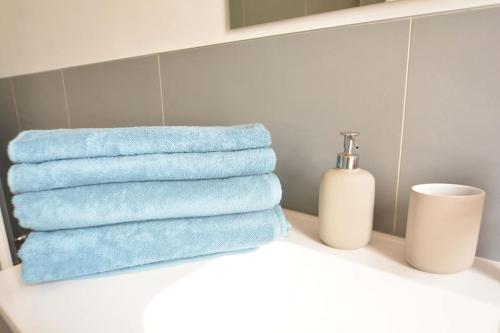 a pile of towels sitting on a shelf in a bathroom at Giotto garden view - pieno centro in Padova
