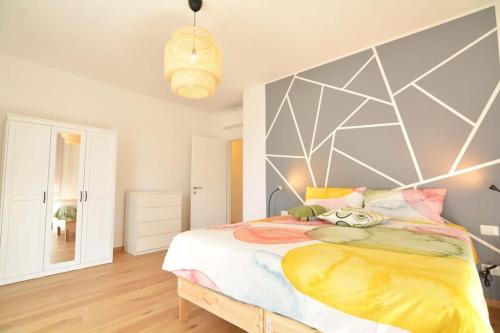 a bedroom with a large bed with a geometric headboard at Giotto garden view - pieno centro in Padova