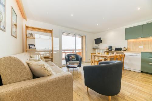 un salon avec un canapé et une cuisine dans l'établissement Homency - Résidence de l'Alpe 30, à L'Alpe-d'Huez