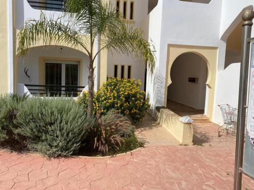 a palm tree in front of a building at Seulement aux familles Luxe appartement en Rdc saidia marina AP2 in Saidia 