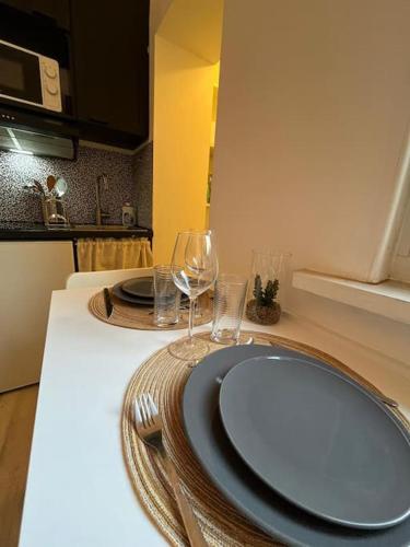 - une table avec deux assiettes et des verres à vin dans l'établissement Gîte Le Nid Douillet 18m2 2 personnes, à Douai