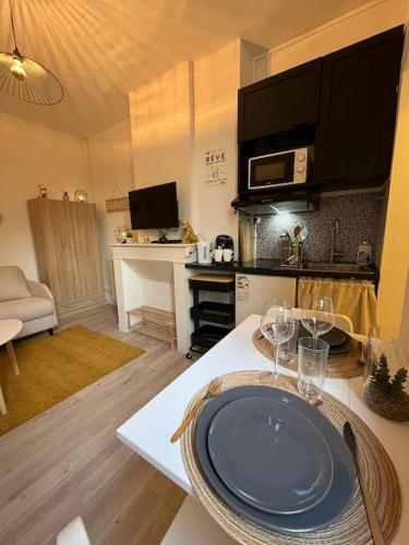 une cuisine avec une table avec des verres à vin dessus dans l'établissement Gîte Le Nid Douillet 18m2 2 personnes, à Douai