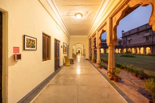an empty hallway of a building with pillars and plants at Umed Bhawan Palace, Kotah in Kota