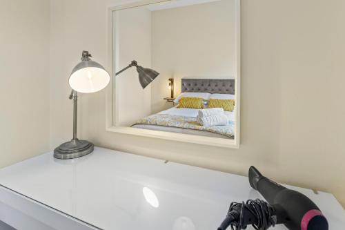 a bedroom with a mirror and a desk with a lamp at Riverside Townhouse Antrim in Antrim