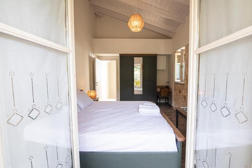 a bedroom with a bed with white sheets at Lagadia Stone House in Agios Nikitas