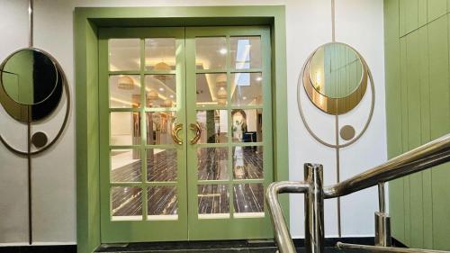 a green door in a building with two mirrors at The Gamora in Gwalior