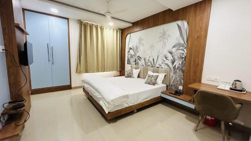 a bedroom with a bed with a large painting on the wall at The Gamora in Gwalior