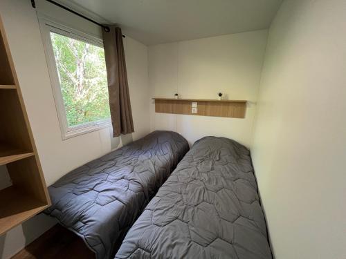 une chambre avec deux lits et une fenêtre dans l'établissement Camping de Montlouis-sur-Loire, à Montlouis-sur-Loire