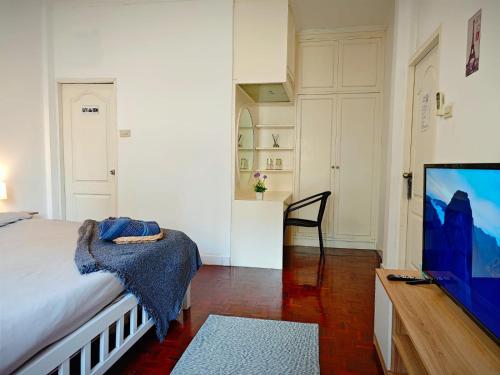 a bedroom with a bed and a flat screen tv at homey stay and cafe by hematoa in Bangkok