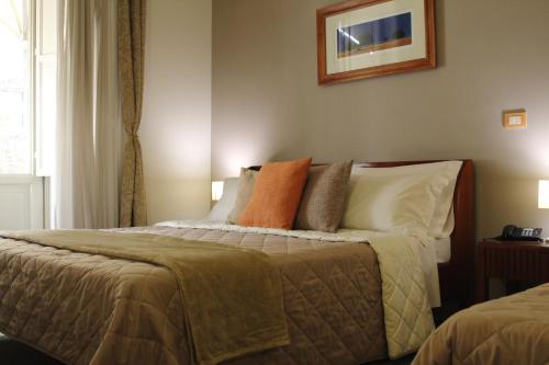 a bedroom with a large bed with pillows at Hotel Agathae in Catania