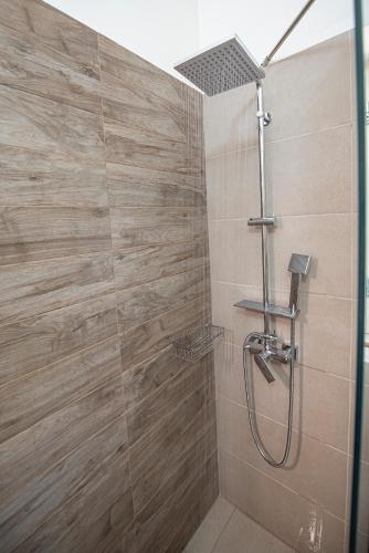 a bathroom with a shower with a glass door at Lagadia Stone House in Agios Nikitas