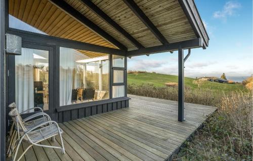 a wooden deck with a chair on a house at 3 Bedroom Lovely Home In Knebel in Knebel