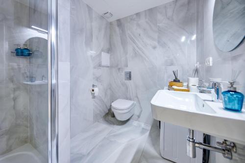 a white bathroom with a toilet and a sink at CityLife Residence in Bratislava