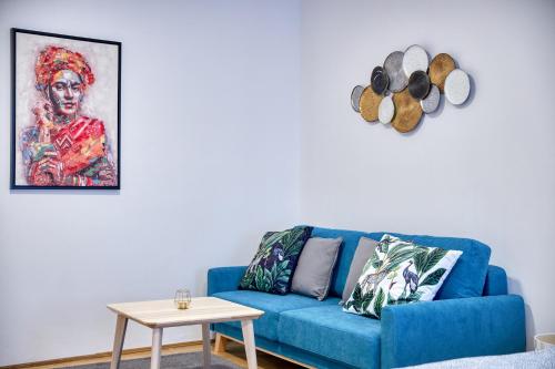 a blue couch in a living room with a table at CityLife Residence in Bratislava