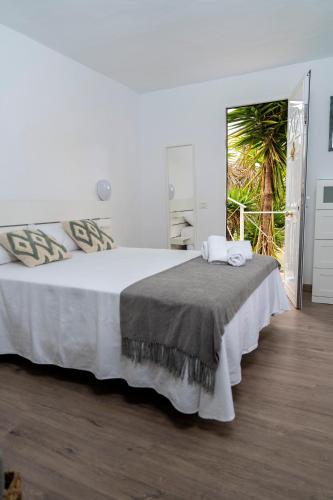 a bedroom with a large white bed and a window at Casa Rosendo Madre in La Guancha