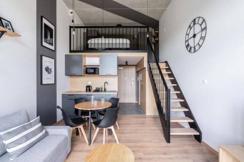 a kitchen and a living room with a table and chairs at RentPlanet - Apartamenty Zarembowicza II in Wrocław