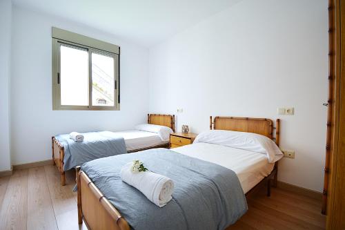 zwei Einzelbetten in einem Zimmer mit Fenster in der Unterkunft Apartamento con terraza en San Vicente in O Grove