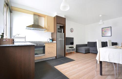 eine Küche und ein Wohnzimmer mit einer Couch und einem Tisch in der Unterkunft Apartamento con terraza en San Vicente in O Grove