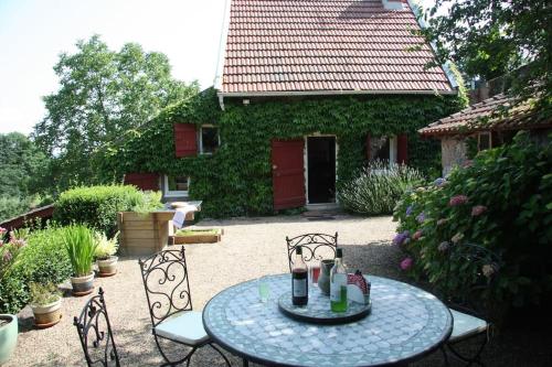 a patio with a table and chairs in a yard at Cottage chaleureux avec Cheminée au Calme in Beaubery