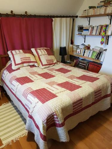 une chambre avec un lit avec un rideau rouge dans l'établissement Cottage chaleureux avec Cheminée au Calme, à Beaubery