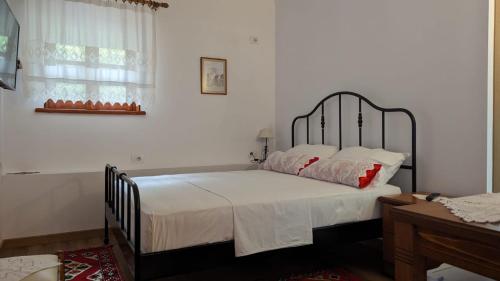 a bedroom with a bed with white sheets and red pillows at Old Town Hotel in Gjirokastër