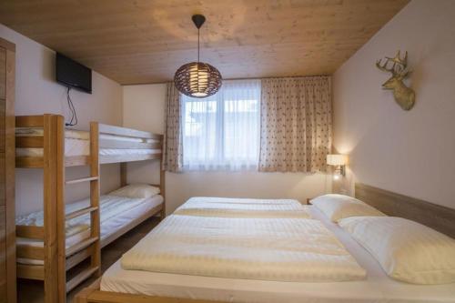 a bedroom with two bunk beds and a window at Residenz Wildkogelbahnen Top 16 in Neukirchen am Großvenediger