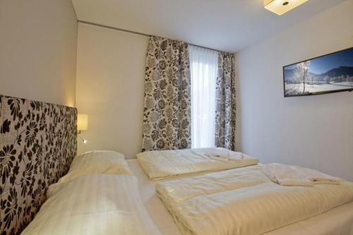 two beds in a room with a window at Residenz Wildkogelbahnen Top 19 in Neukirchen am Großvenediger
