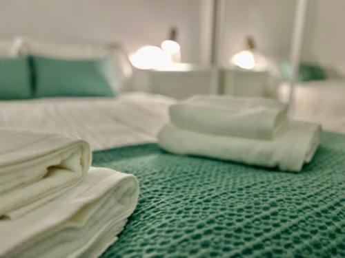 a pile of white sheets sitting on a green carpet at Balnea Baiona in Baiona