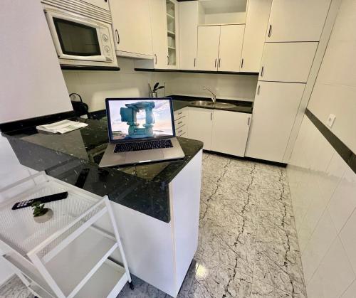 a laptop computer sitting on a counter in a kitchen at Balnea Baiona in Baiona