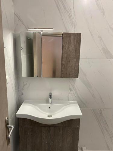 a bathroom with a white sink and a mirror at Four Seasons in Leptokaria